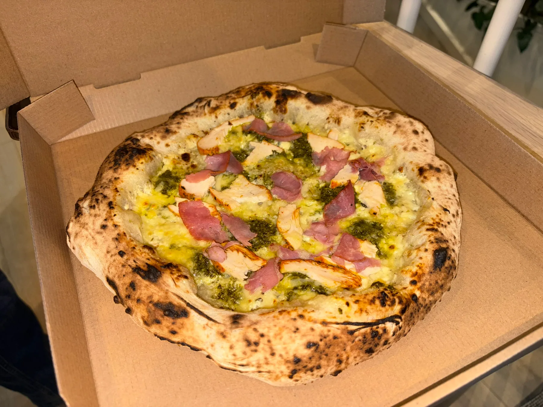 Nystekt pizza med kylling og spekeskinke i en takeaway-eske